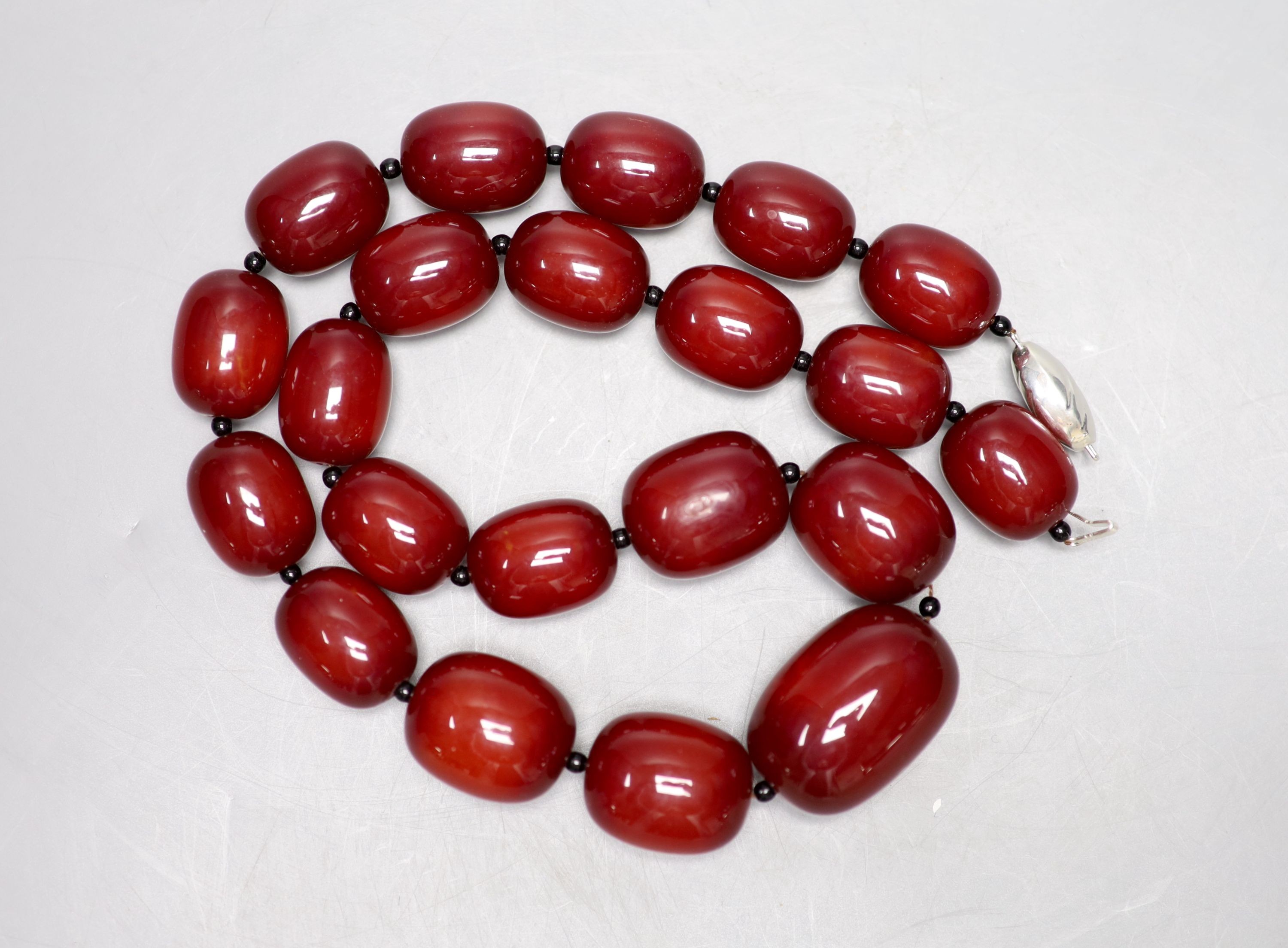 A single strand graduated simulated cherry amber bead necklace, 66cm, gross weight 216 grams.
